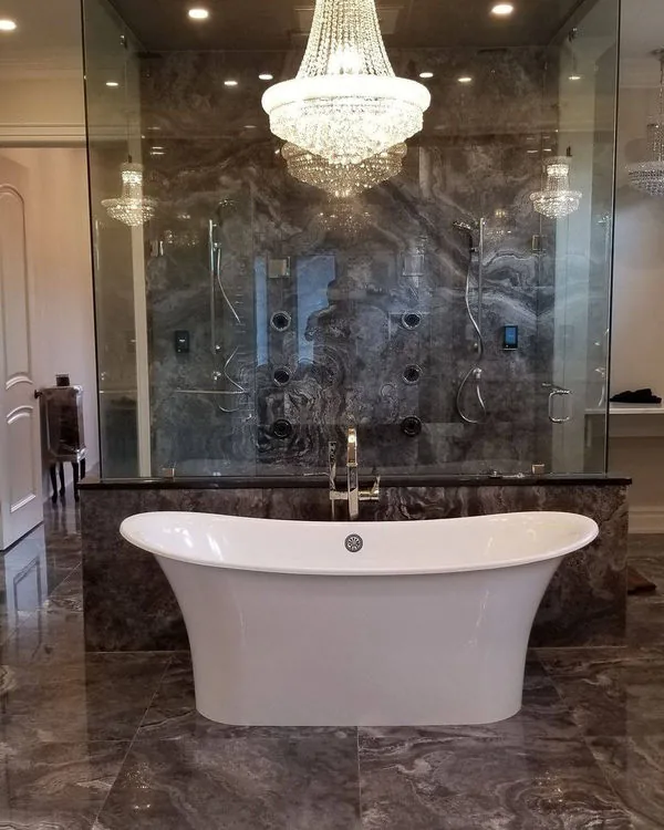 Bathroom renovation with large format marble tile and a freestanding tub